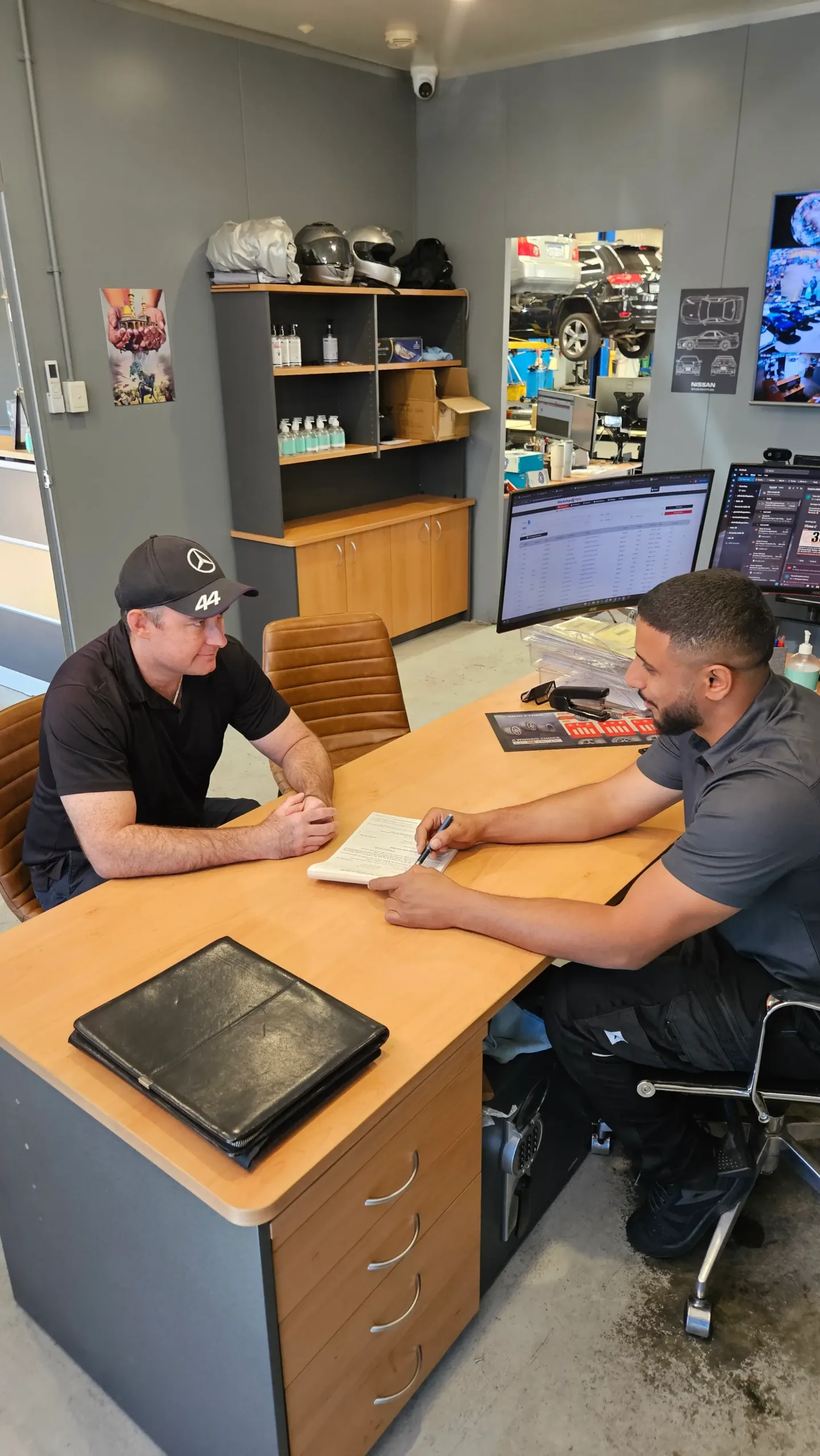Sell My Car Pro buyer going through finance payout paperwork with a seller
