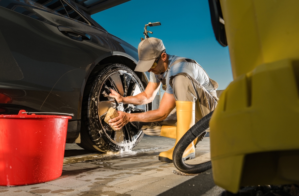 Man cleaning a car prior to the end of the financial year to sell it