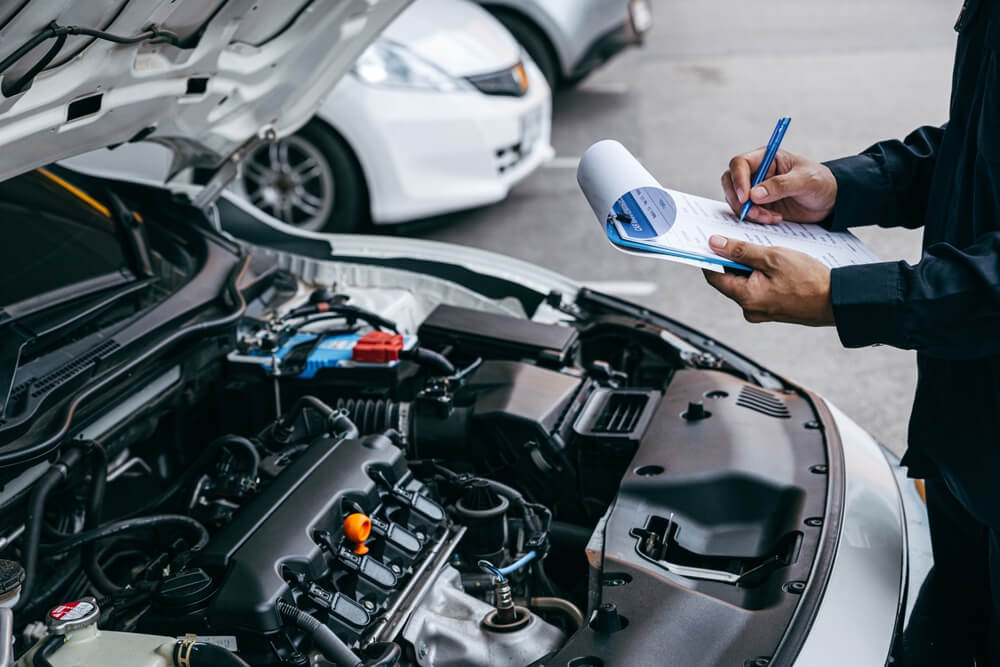 Mechanic inspecting car for roadworthiness