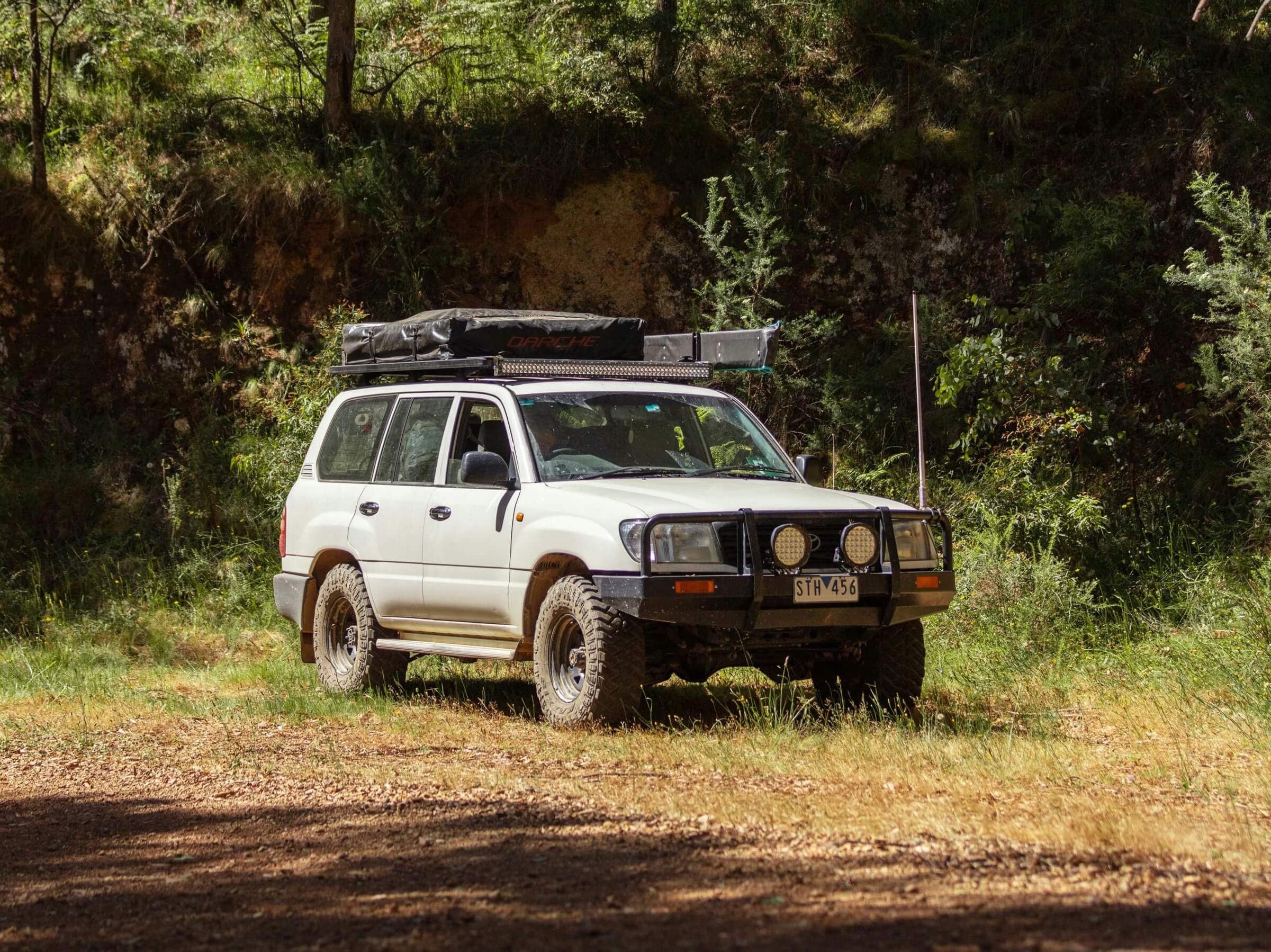 Older Model Toyota Landcruiser off roading in a forest
