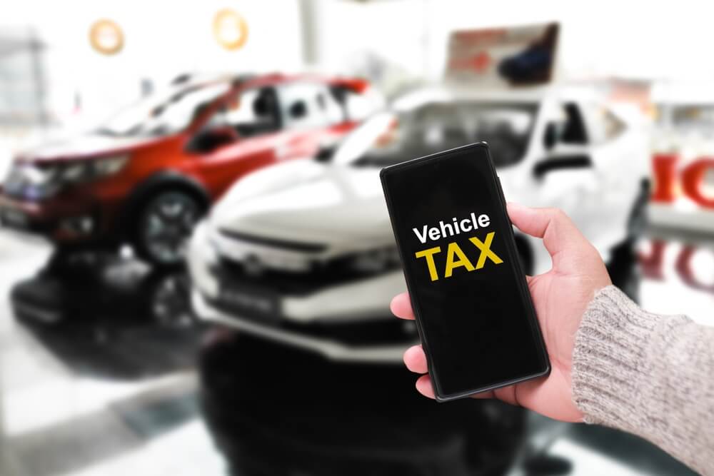 Vehicle tax information on smartphone screen at car dealership
