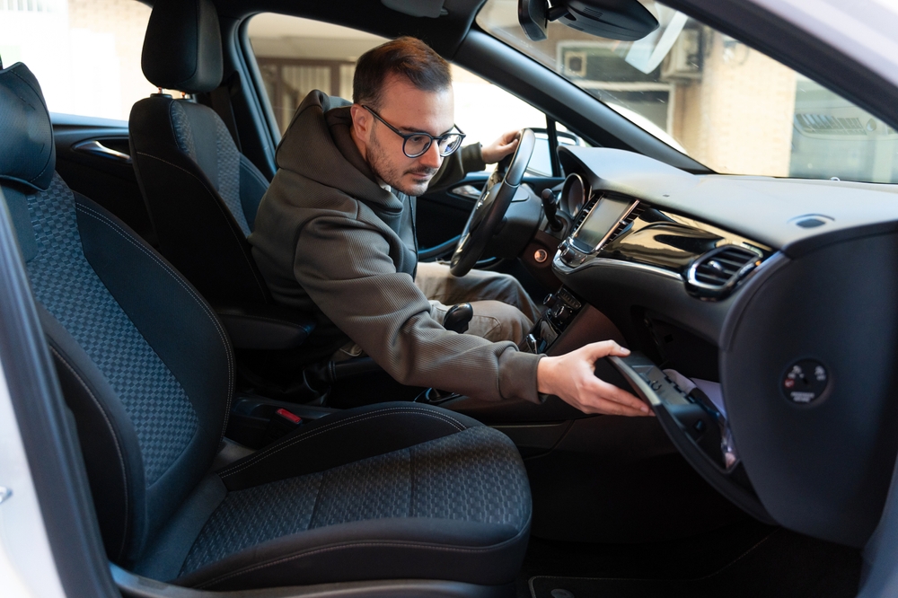 Young man searching inside the cars glove box
