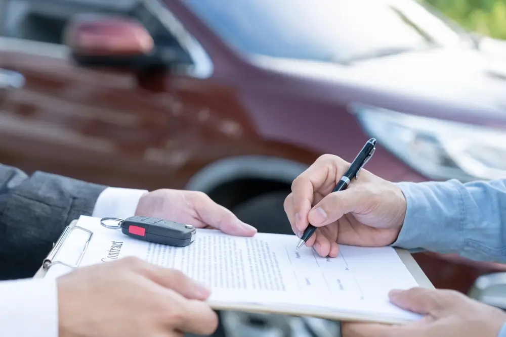Buyer and seller completing a car sale with the airbag fault disclosed in writing