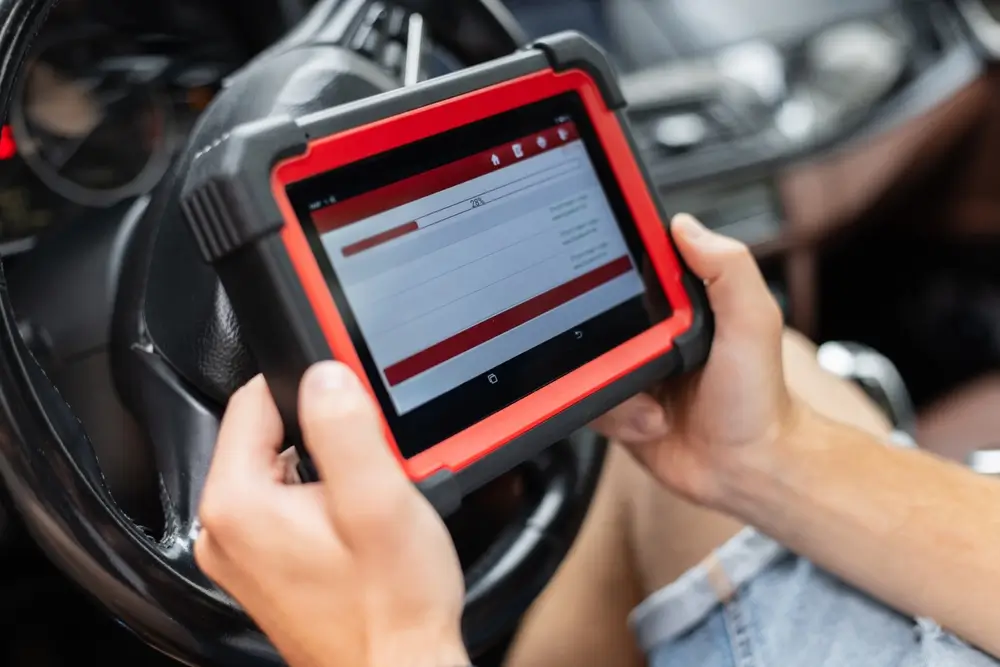 Technician reading SRS fault codes with a diagnostic scan tool